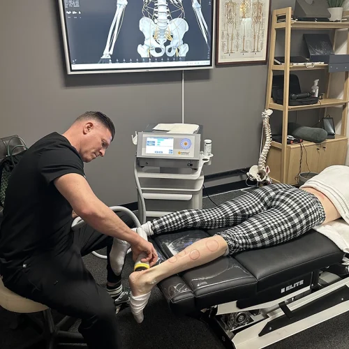 Provider performing SoftWave therapy on a patient's ankle