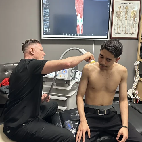Provider performing SoftWave therapy on a patient's shoulder